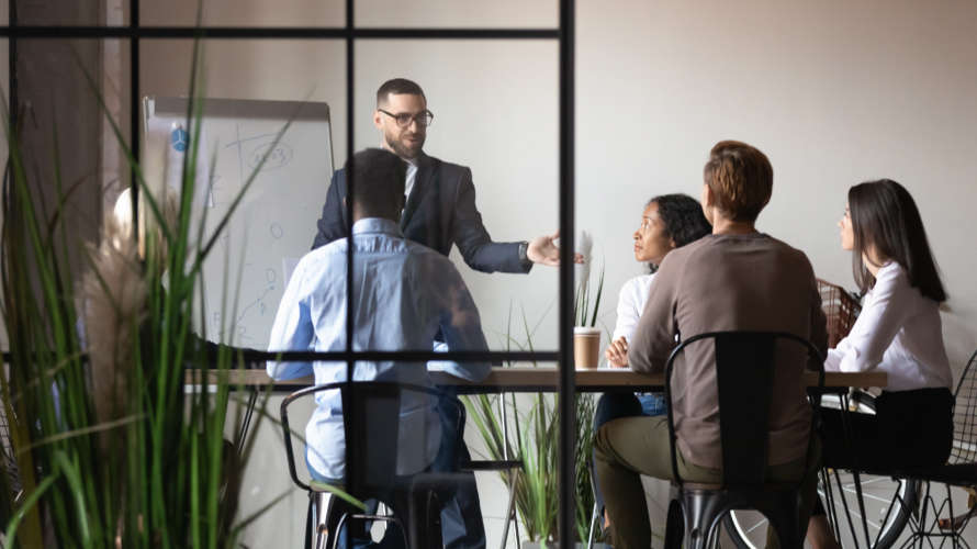 view-through-glass-wall-businesspeople-brainstorming-at-board-room