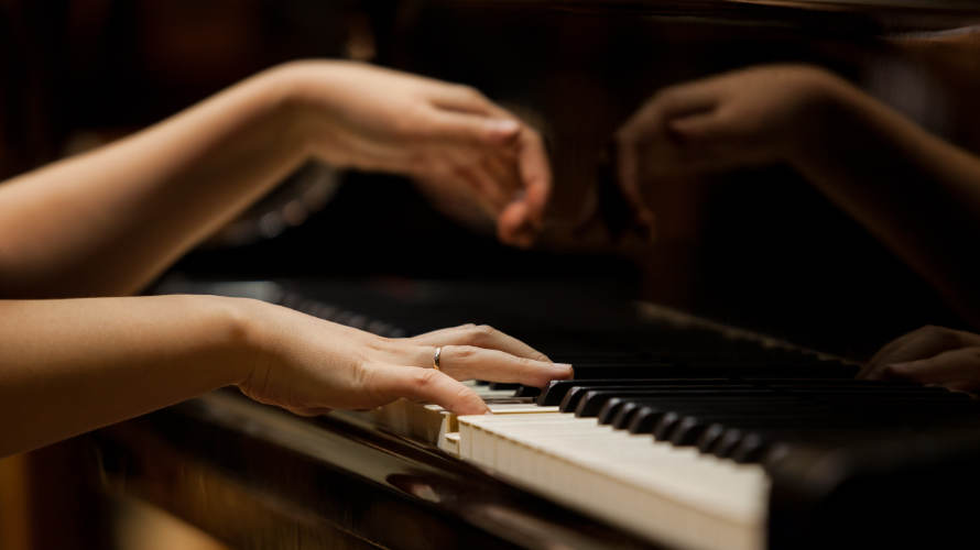 mujer-tocando-teclas-del-piano-en-una-orquestra